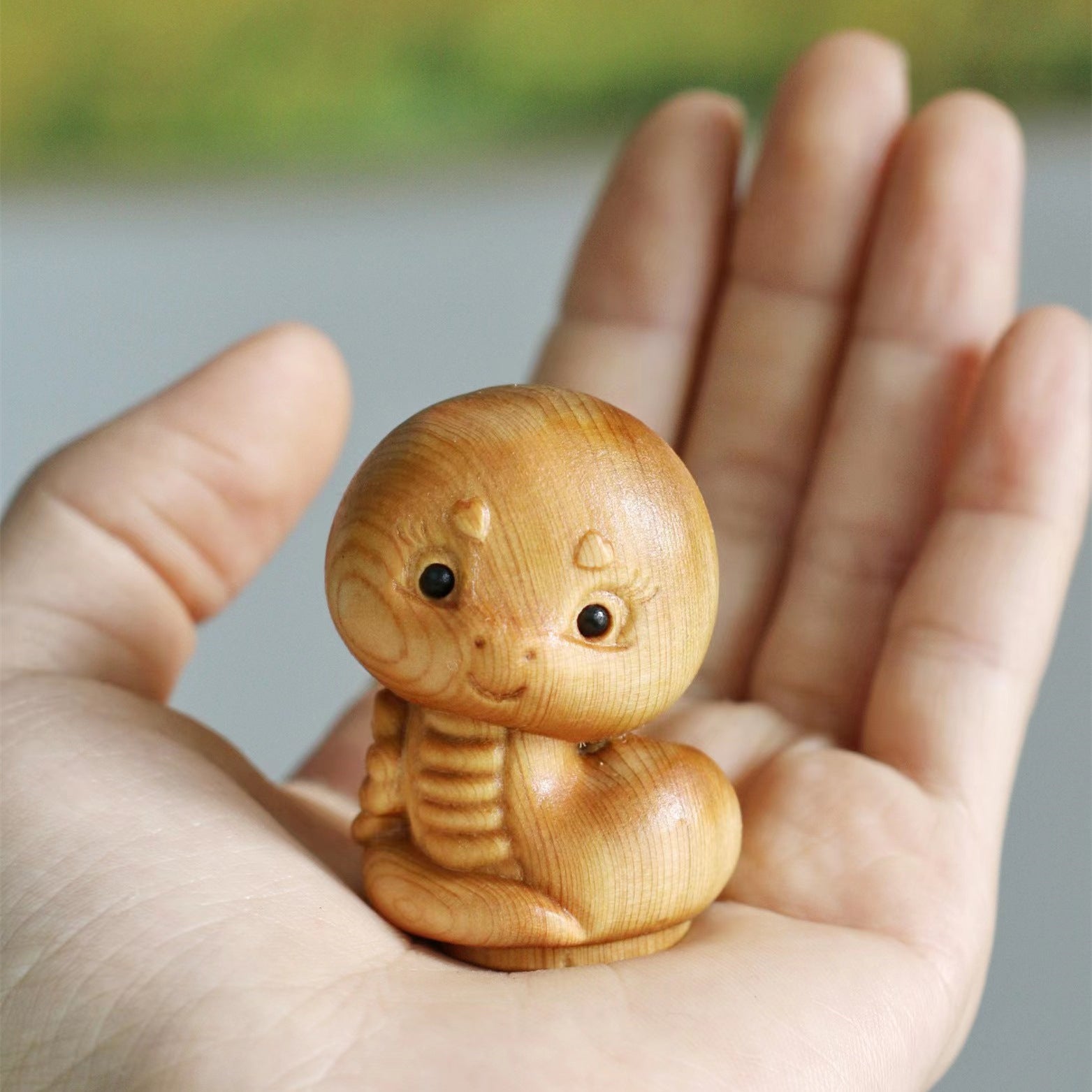 a small wooden toy sitting on top of a person's hand