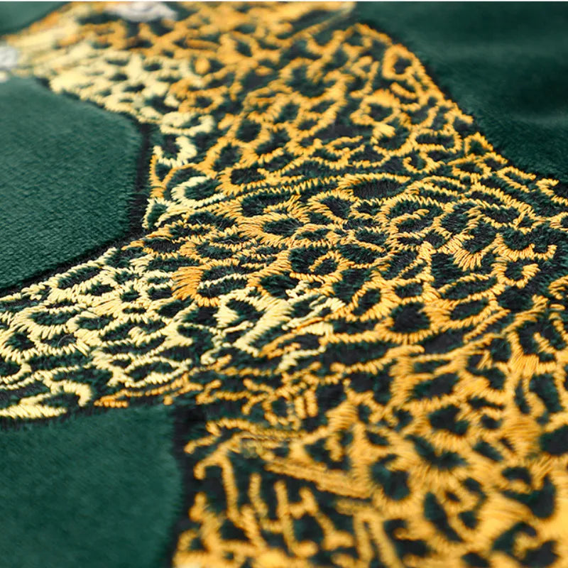 Green velvet sofa cushion showcasing golden leopard pattern