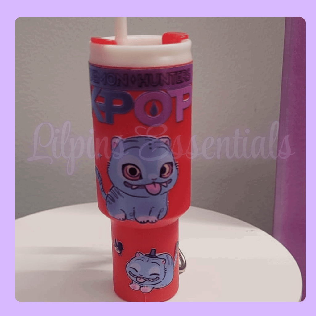 Red tumbler with a kpop design and 'Monsters, Inc.' text on a white surface.