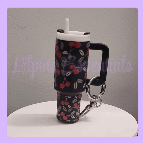 Miniature cup with cherry pattern and keychain on a gray background