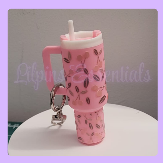 Pink water bottle-shaped keychain with floral design 