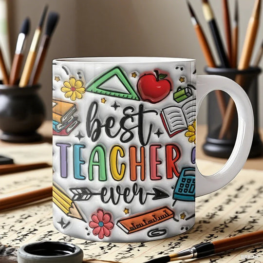 Mug with 'best teacher ever' text and colorful illustrations on a desk with art supplies.