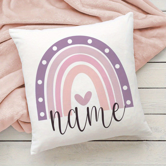 Decorative pillow with a rainbow design and the word 'name' on a pink blanket.