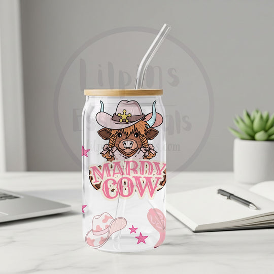 Pink cowgirl Highland cow glass tumbler with bamboo lid and clear plastic straw on a desk